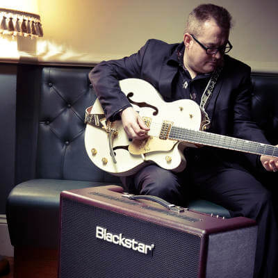 Boz Boorer playing his guitar with a blackstar guitar amp in front