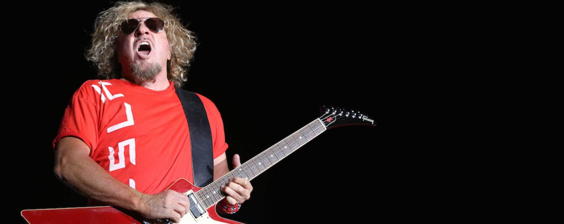 man in glasses playing his guitar